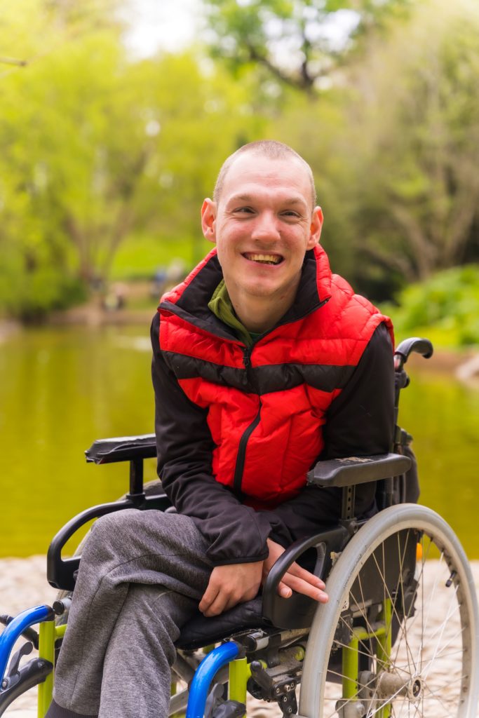 jeune homme assis dans un fauteuil roulant électrique