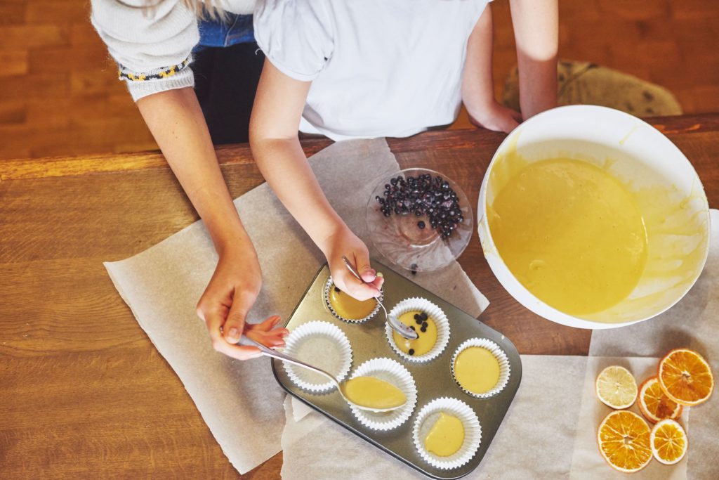 Enfant cuisinant des muffins avec l'aide d'une adulte