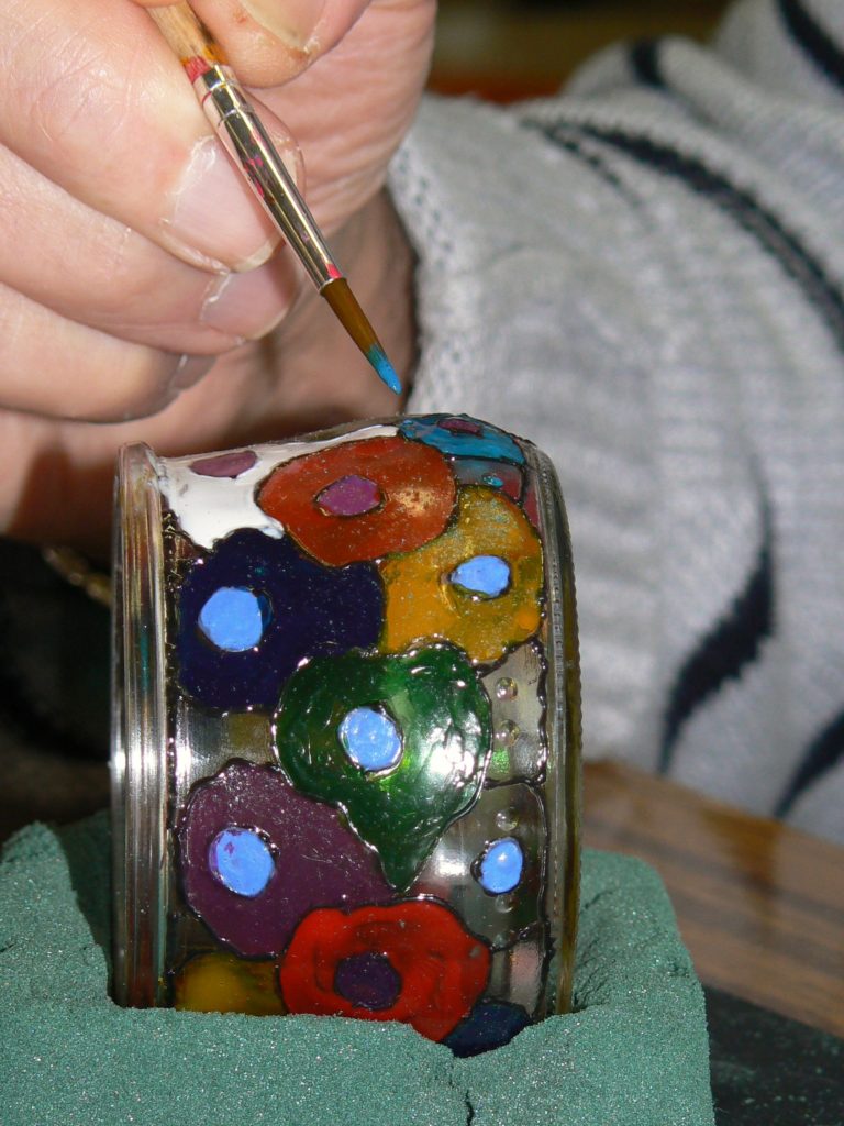 Participant d'un atelier faisant de la peinture sur verre